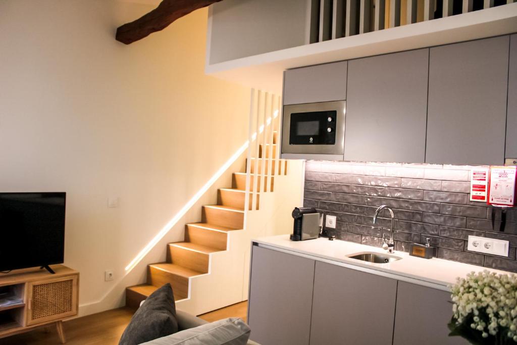 a living room with a sink and a staircase at Casa de Couros in Guimarães