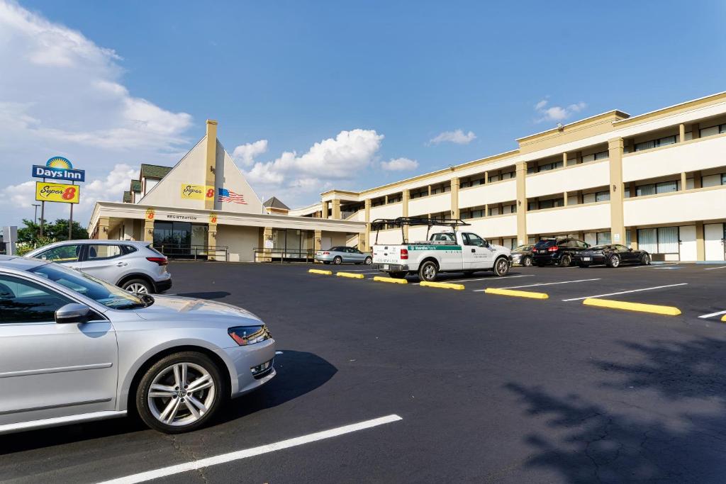 ein Parkplatz mit Autos vor dem Hotel in der Unterkunft Super 8 by Wyndham WestEnd Alexandria,VA Washington DC Area in Alexandria