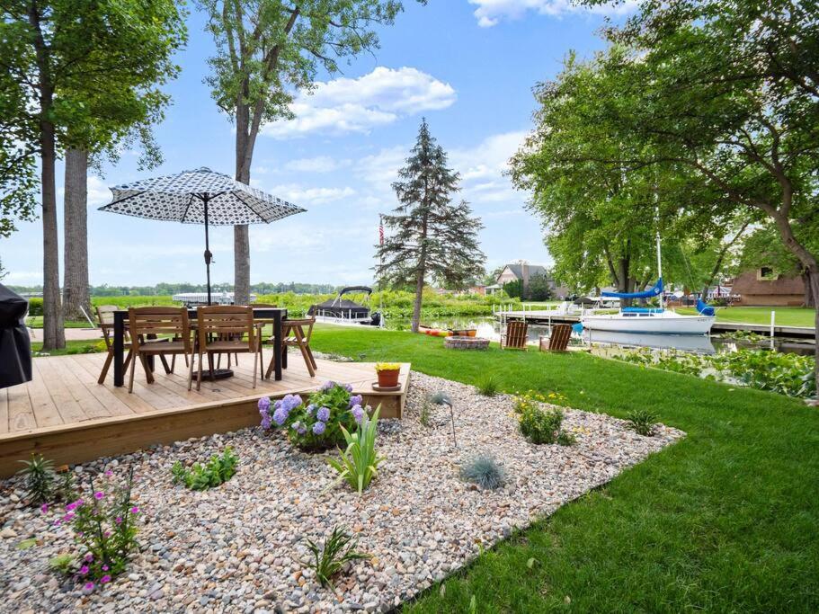 a backyard with a table and an umbrella at Adorable Wawasee Cottage in Oakwood Park in Syracuse