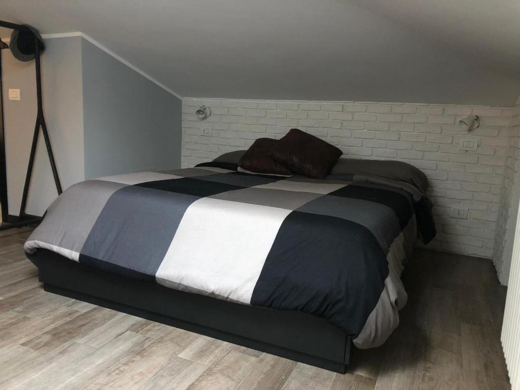 a large bed in a bedroom with a brick wall at Gioconda’s Apartment in Rome