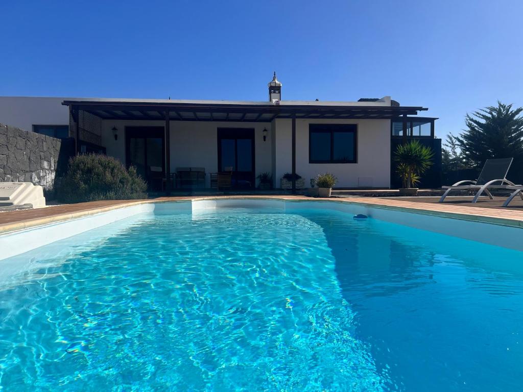 a swimming pool in front of a house at Villa Jaira in La Vegueta