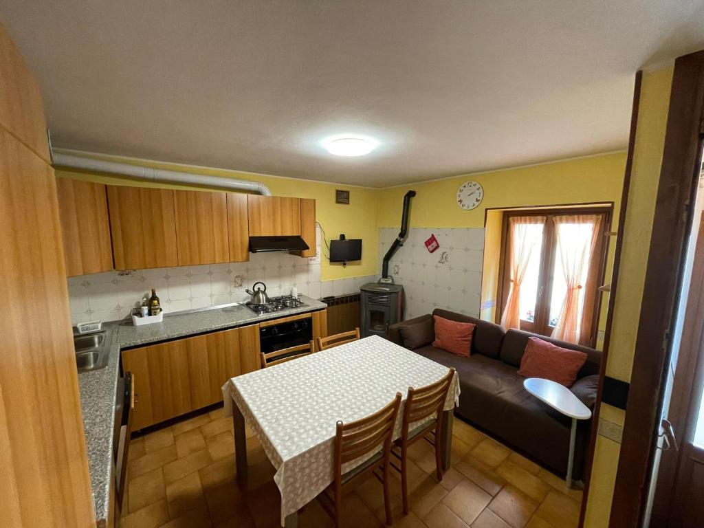 uma cozinha e uma sala de estar com uma mesa e um sofá em Rosa Mountain Lake Iseo Hospitality em Bossico