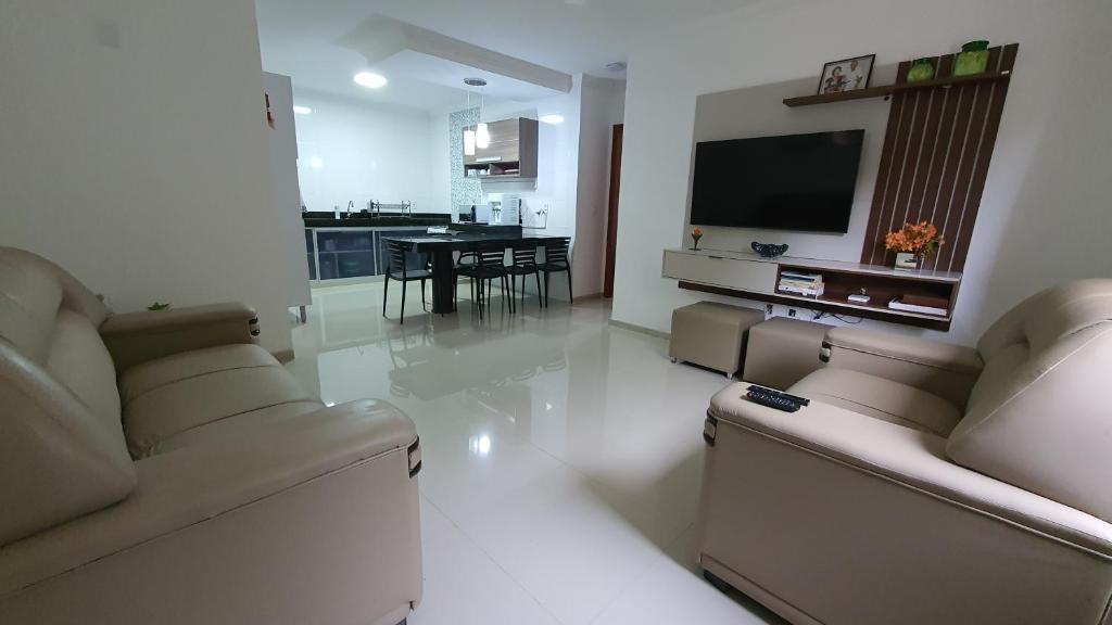 - un salon avec deux canapés et une télévision à écran plat dans l'établissement Recanto do Mundaí - Apto 202, à Porto Seguro