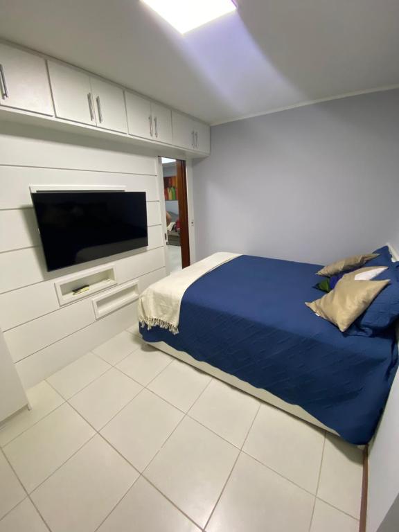 1 dormitorio con 1 cama y TV de pantalla plana en Beach thoow férias, en Arraial do Cabo