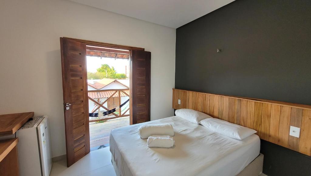 Dormitorio pequeño con cama y ventana en Pousada Vila Cajuína - Parnaíba en Parnaíba