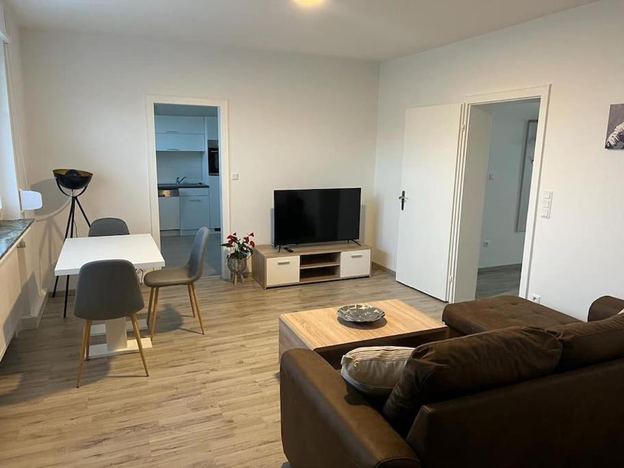 a living room with a couch and a table and a television at Eine modern renovierte Wohnung mit Balkonterrasse. in Lübbecke