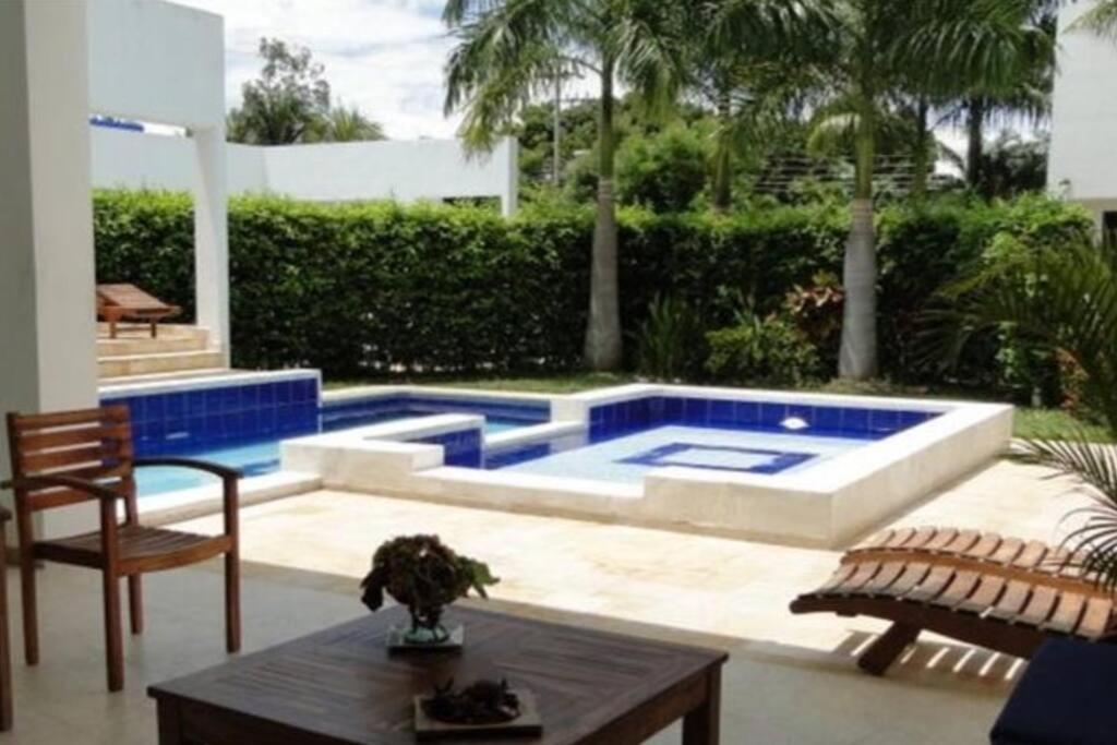 a pool in a backyard with a table and chairs at Casa Girardot in Ricaurte