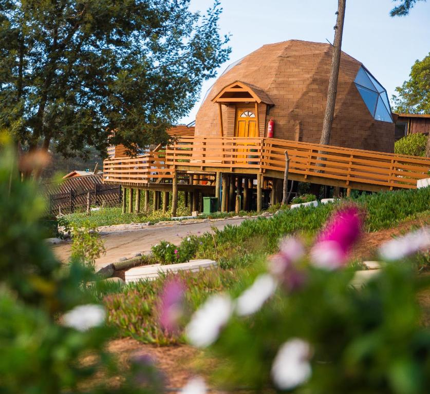 a large dome shaped building with a porch and flowers at Lemudomos in Pichilemu
