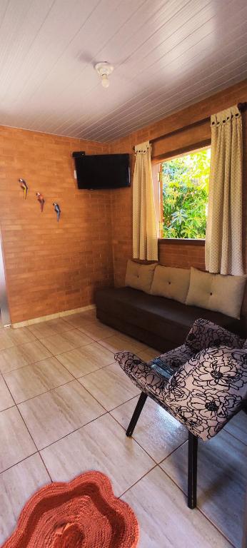 a living room with a couch and a window at Fazenda Rosmaninho in Alto Paraíso de Goiás