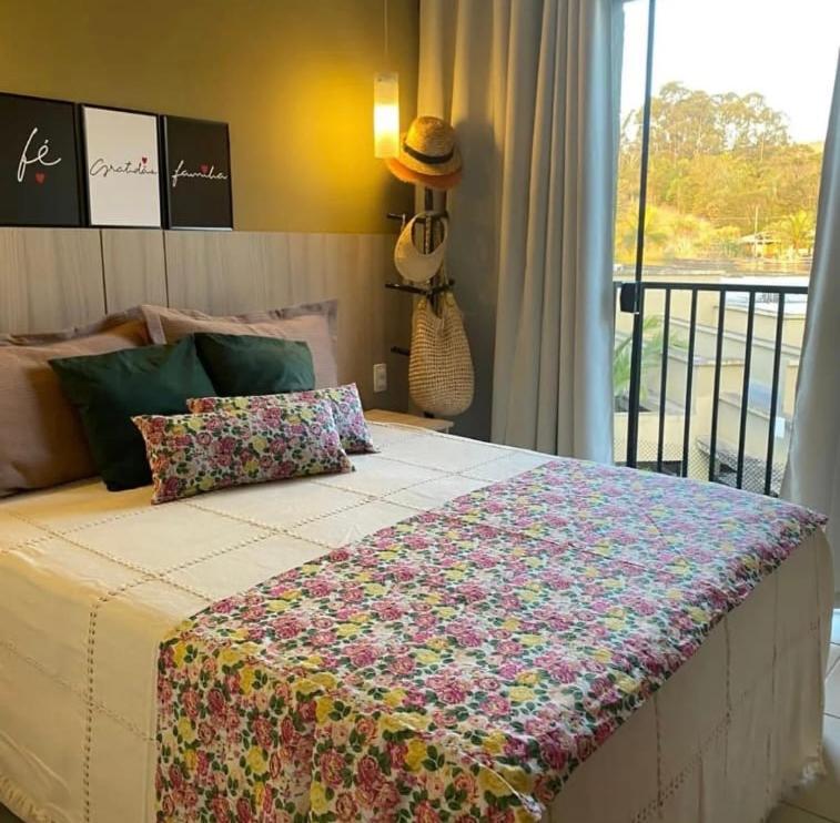 Un dormitorio con una cama con una manta. en Aldeia das Águas Park Resort - Flat B309 Quartier en Barra do Piraí
