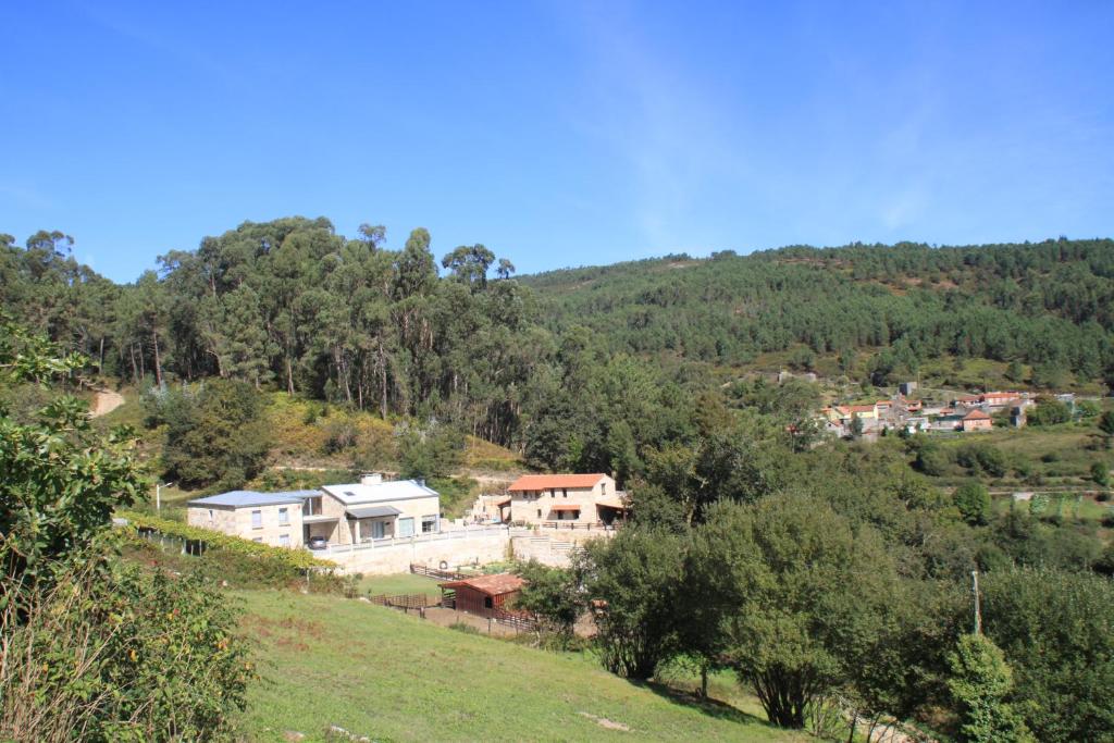 un groupe de maisons sur une colline plantée d'arbres dans l'établissement Hotel a Ecogranxa, à Pontevedra