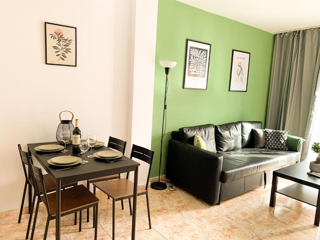 een woonkamer met een tafel en een bank bij Apartamentos OlaMar in Lloret de Mar