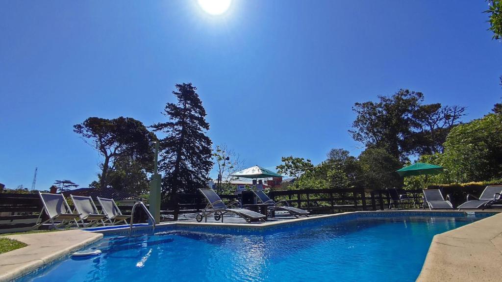 una piscina con hamacas y el sol en Apart Octogono Condominio en Villa Gesell