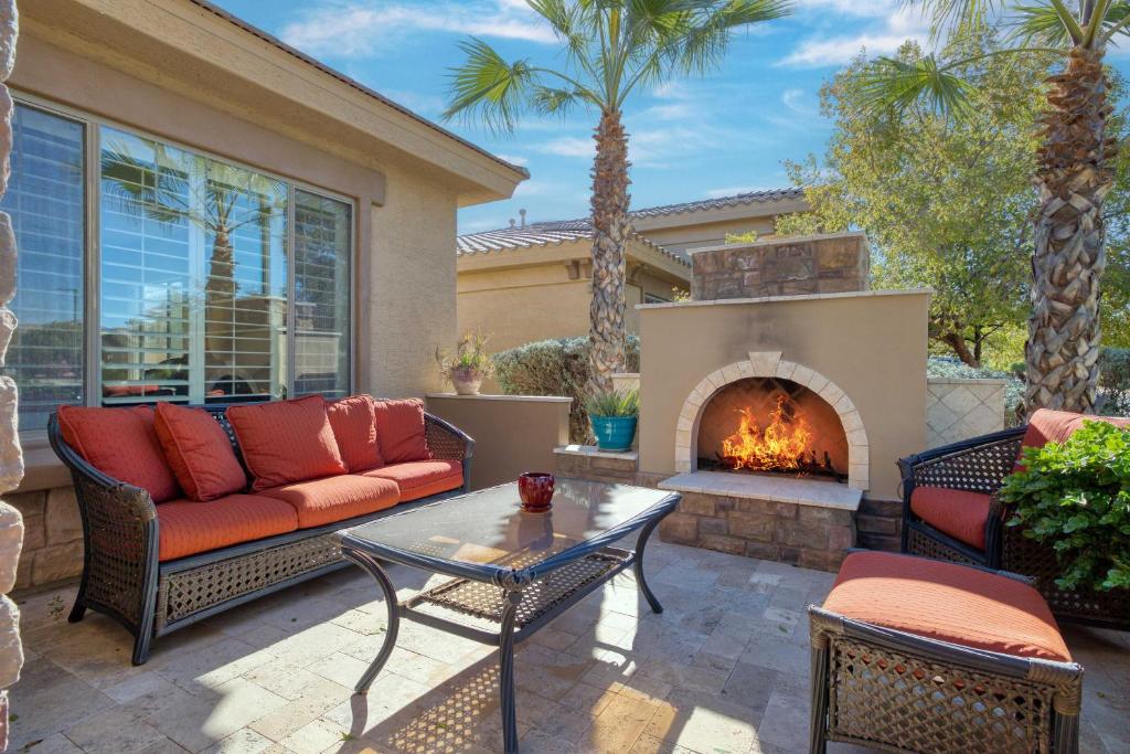 a patio with a couch and a fireplace at Modern Paradise: King Bed + EV Charger +Pool Table in Goodyear