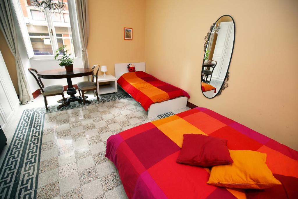 ローマにあるジュリエッタ アル コロッセオB＆Bのベッドルーム1室(ベッド2台、テーブル、鏡付)