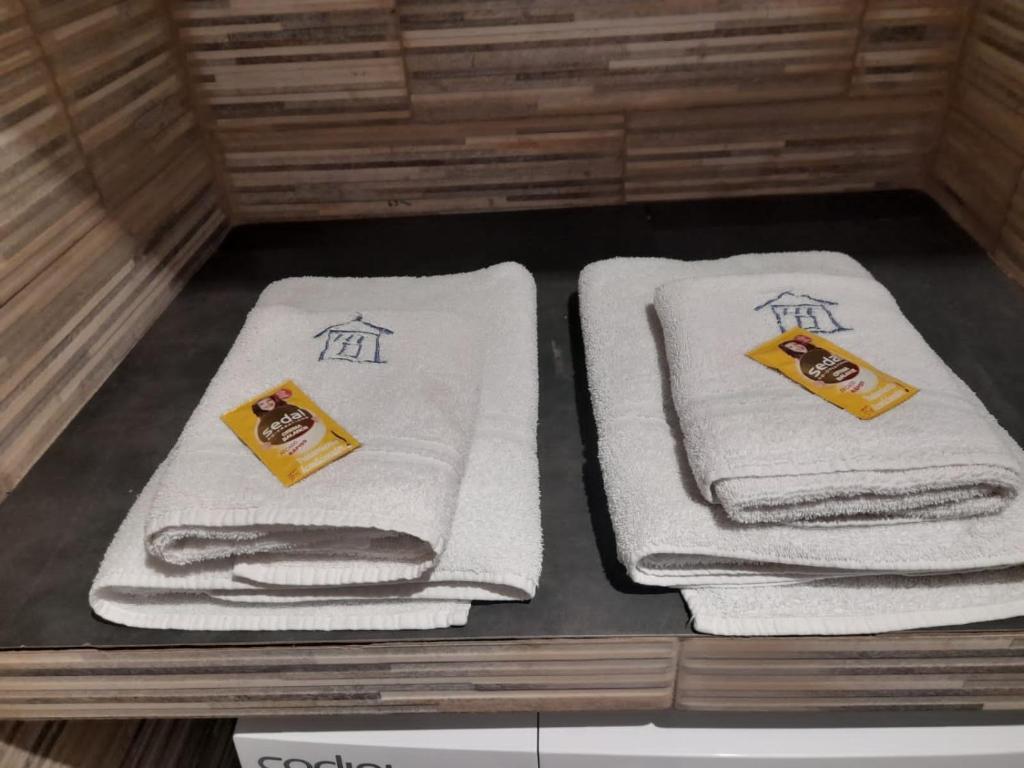 two stacks of towels on a shelf in a bathroom at Monoambientes in Villa Alsina