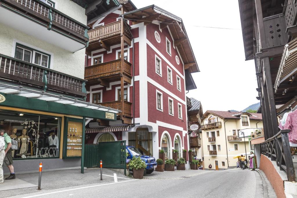 een rood-wit gebouw aan de straatkant bij Villa Anzengruber in St. Wolfgang