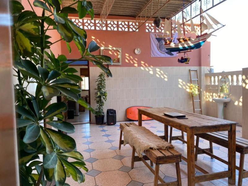 una mesa y un banco en una habitación con plantas en casanostra en Agadir