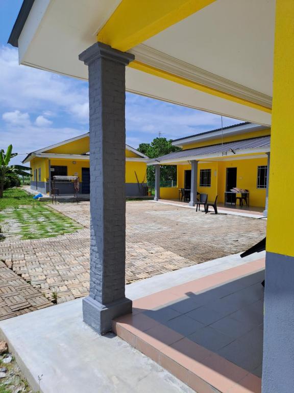 un edificio escolar amarillo con un gran patio en Room/Homestay NazaDja, en Sungai Besar