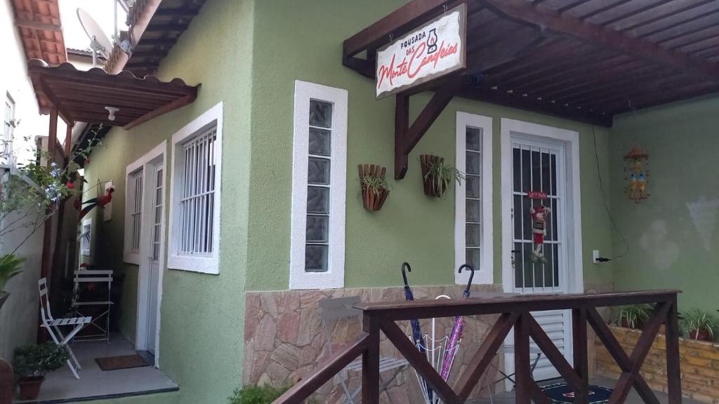 a green building with a sign on the side of it at Pousada Monte das Candeias in Guaramiranga