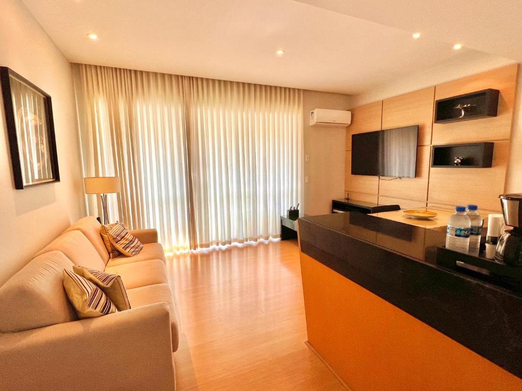 una cucina con divano e bancone in una camera di Flat savassi super luxo a Belo Horizonte