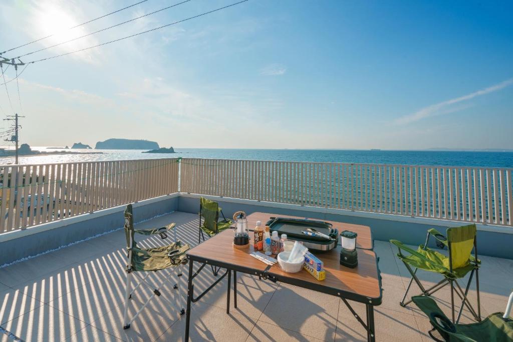 a balcony with a table and chairs and the ocean at Ryushima Ocean View Besso - Vacation STAY 13427 in Minamiboso