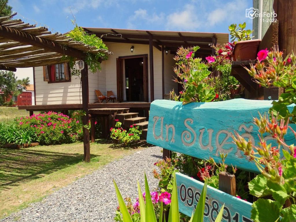 una casa con un cartel en un jardín en Un Sueño, en Punta del Diablo