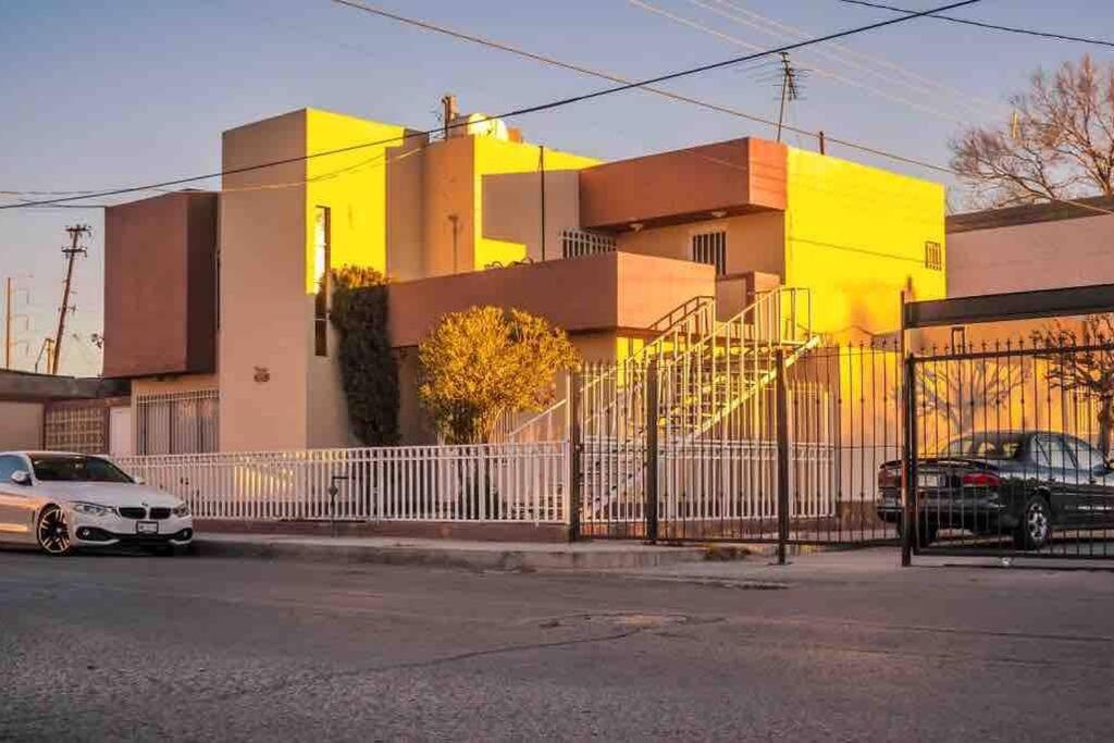 a yellow building with cars parked in front of it at Departamento con Amplia Terraza en Excelente Zona in Ciudad Juárez