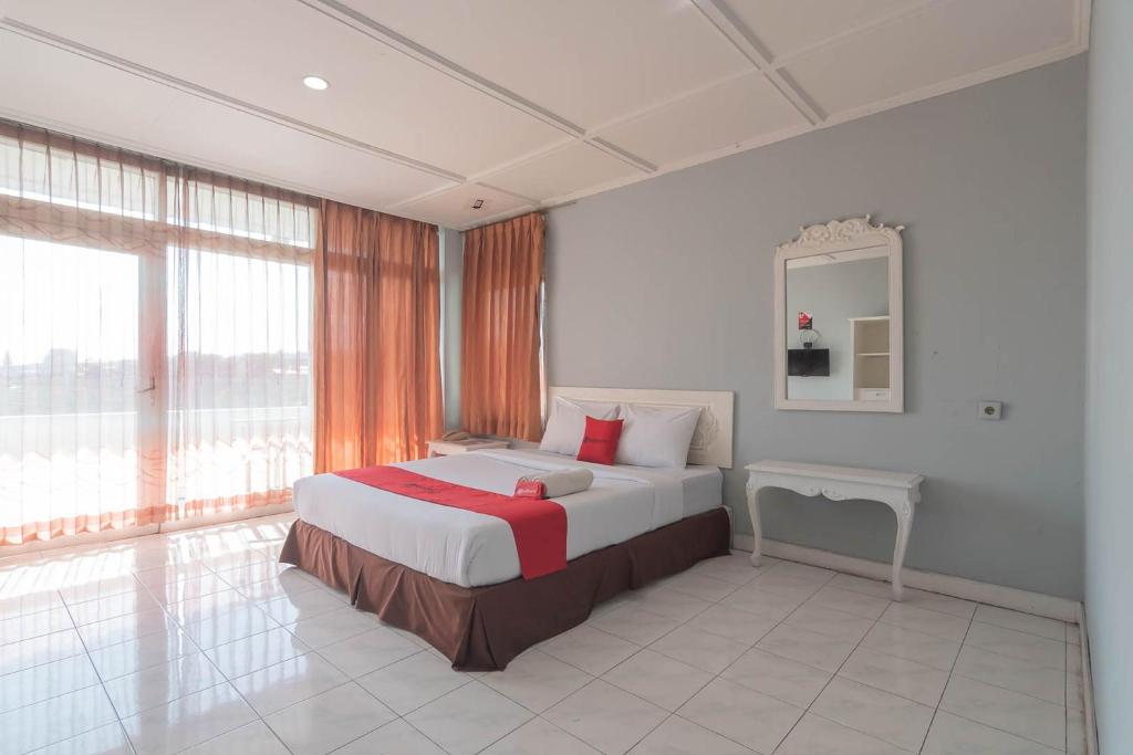 a bedroom with a bed and a large window at RedDoorz At Jalan Raya Lembang in Bandung