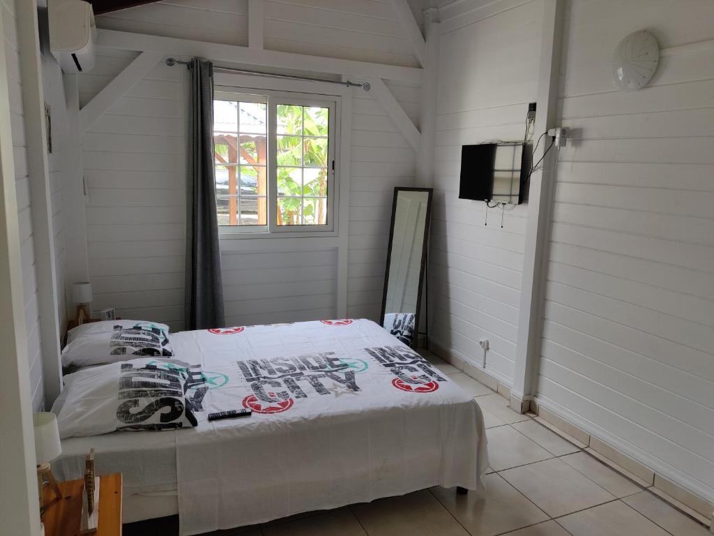 een slaapkamer met een bed en een televisie. bij Keshy island colibri in Baillif