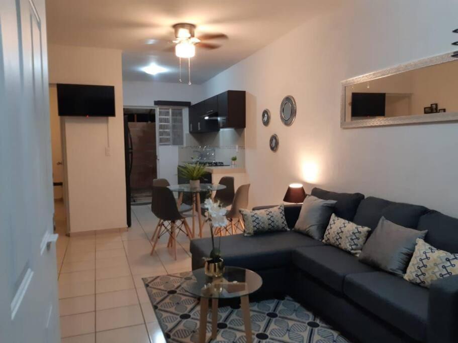 Cómoda Casa a 5 minutos del IMSS في Villa de Alvarez: غرفة معيشة مع أريكة زرقاء وطاولة