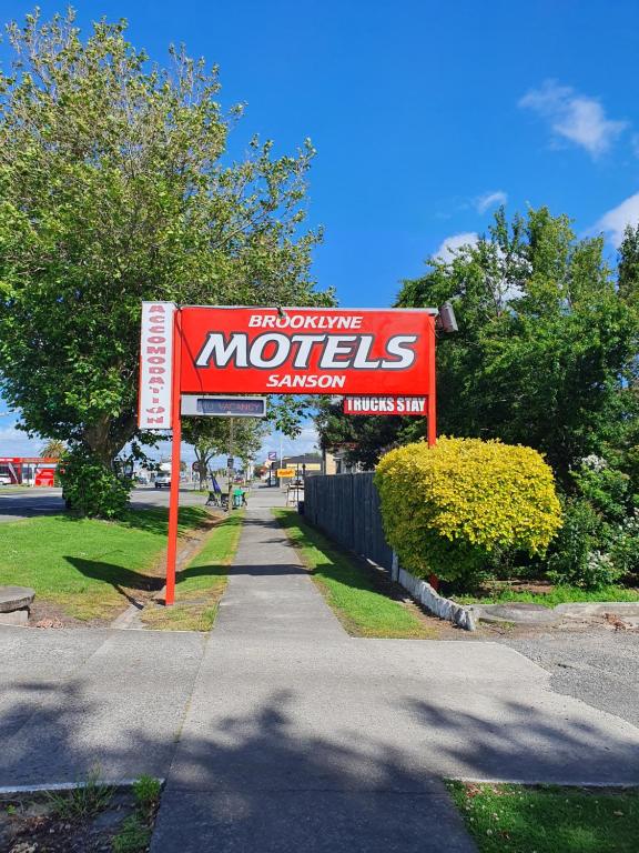 a sign for a motel on the side of a sidewalk at Brooklyne Motel Sanson in Sanson