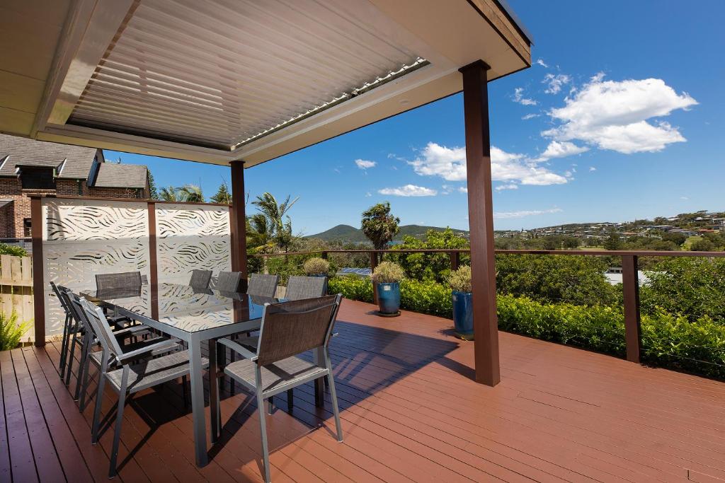 a patio with a table and chairs on a deck at Marine Drive in Forster