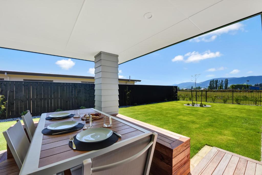 a patio with a table and chairs and a lawn at 39Carmine Five Star 4-bedroom Holiday Home in Appleby