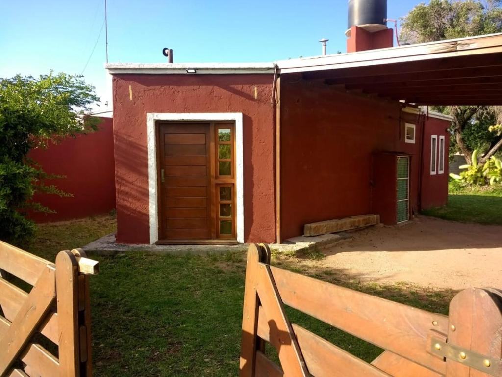 een huis met een houten deur in de tuin bij Casa de campo Los Aloe in Cruz del Eje