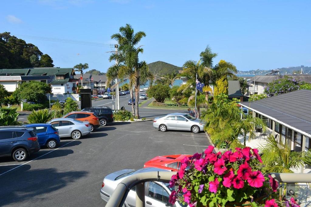 a parking lot with parked cars and flowers at Bounty Motel in Paihia