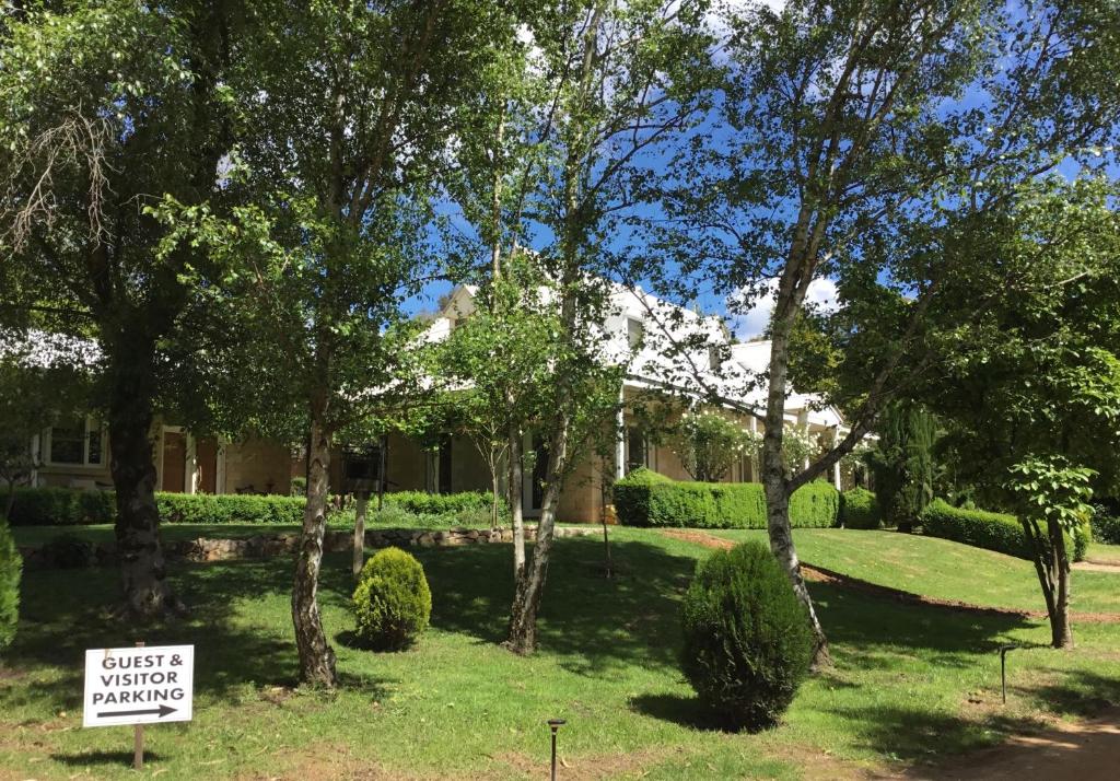 a house with a sign in front of a yard at Beechworth House in Beechworth