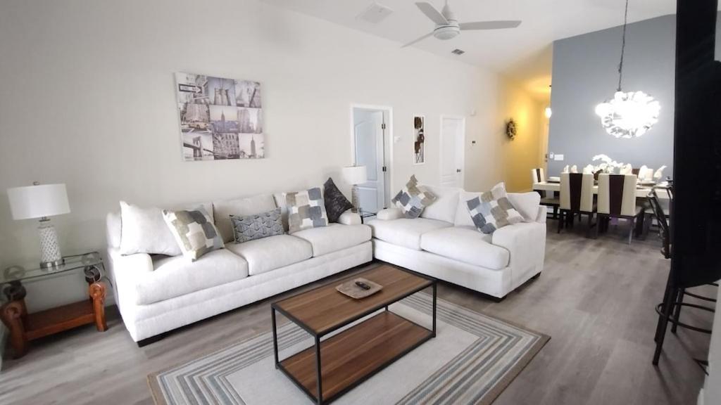 a living room with two white couches and a table at Renovated 5 Bed/3 Bath Villa in Davenport