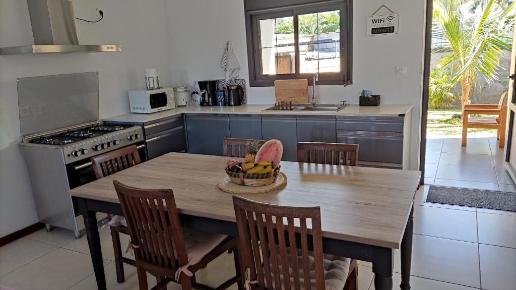 eine Küche mit einem Tisch und einer Obstschale darauf in der Unterkunft Mon oasis in Saint-Louis