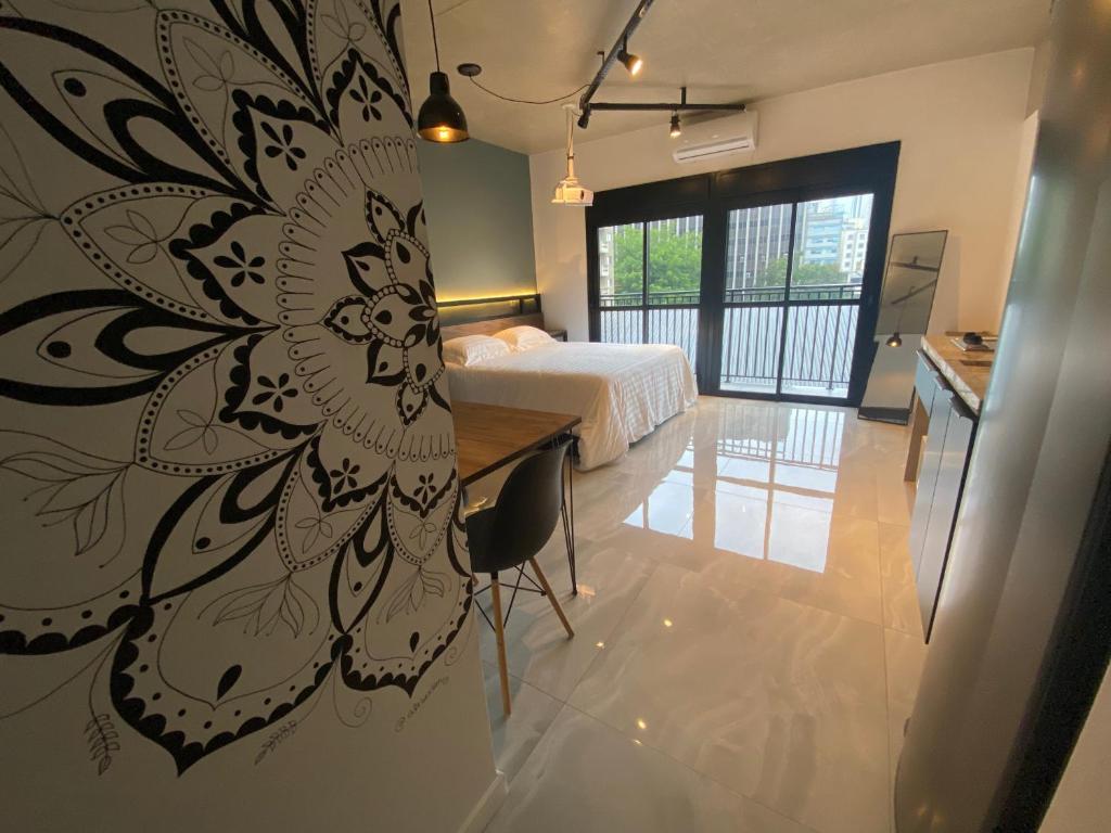 Un dormitorio con una cama y una pared con una flor. en 58 New studio w/ balcony, fast wifi and movie screen!, en São Paulo