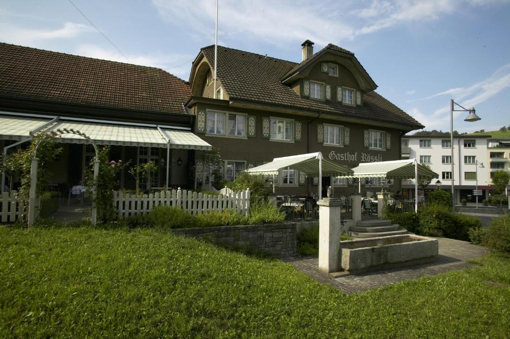 un edificio con una valla blanca delante de él en Landgasthof Hotel Rössli en Luzern