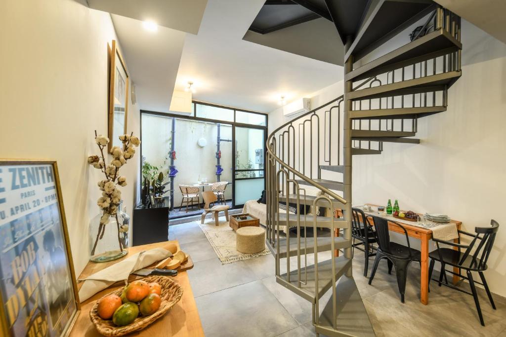 a living room with a spiral staircase and a table at Cozy Modern 1BR Duplex Apt w Balcony Near City Center by Sea N' Rent in Tel Aviv
