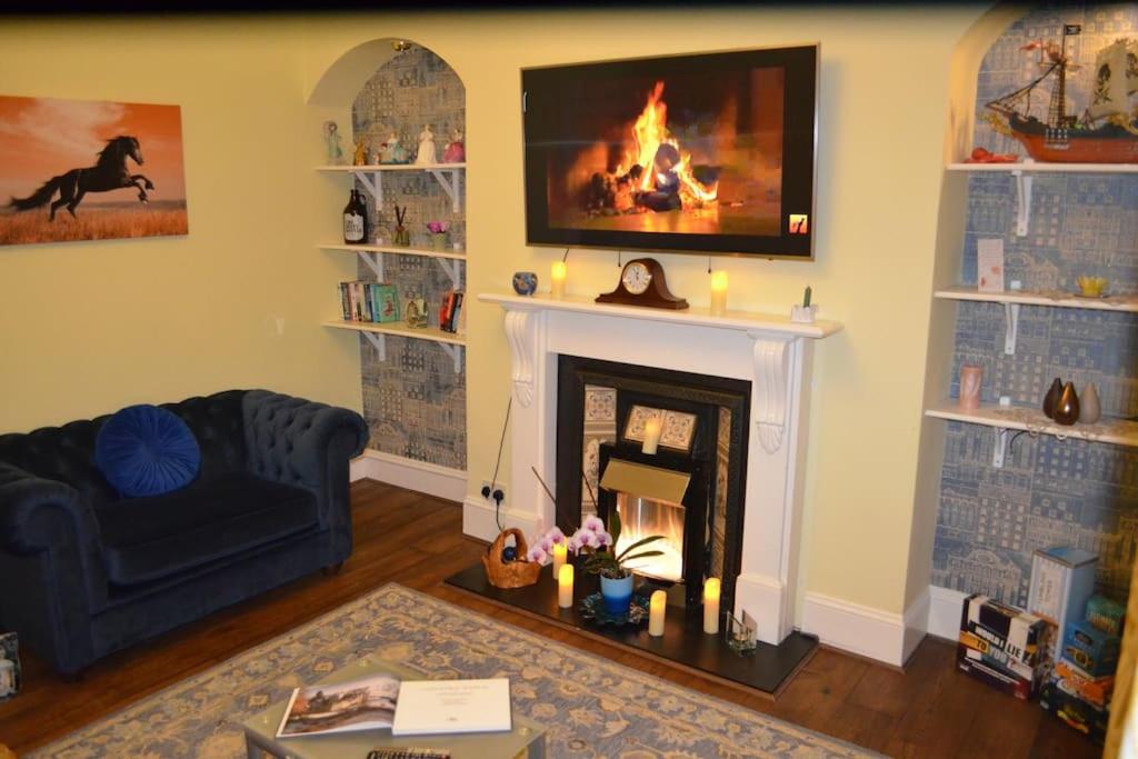 a living room with a fireplace and a tv at Alastrean Flat in Aberdeen