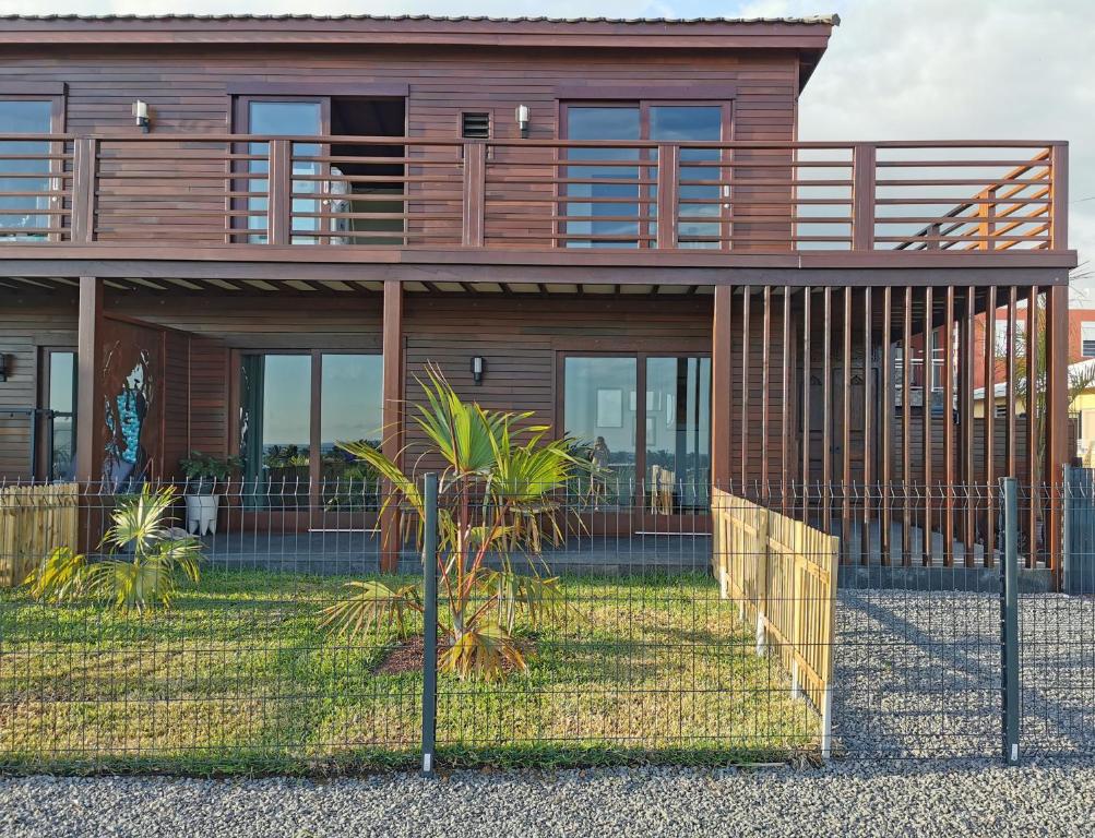 une maison avec une clôture devant elle dans l'établissement Kaz C2C - Une maison Balinaise avec jacuzzi, à Saint-Pierre