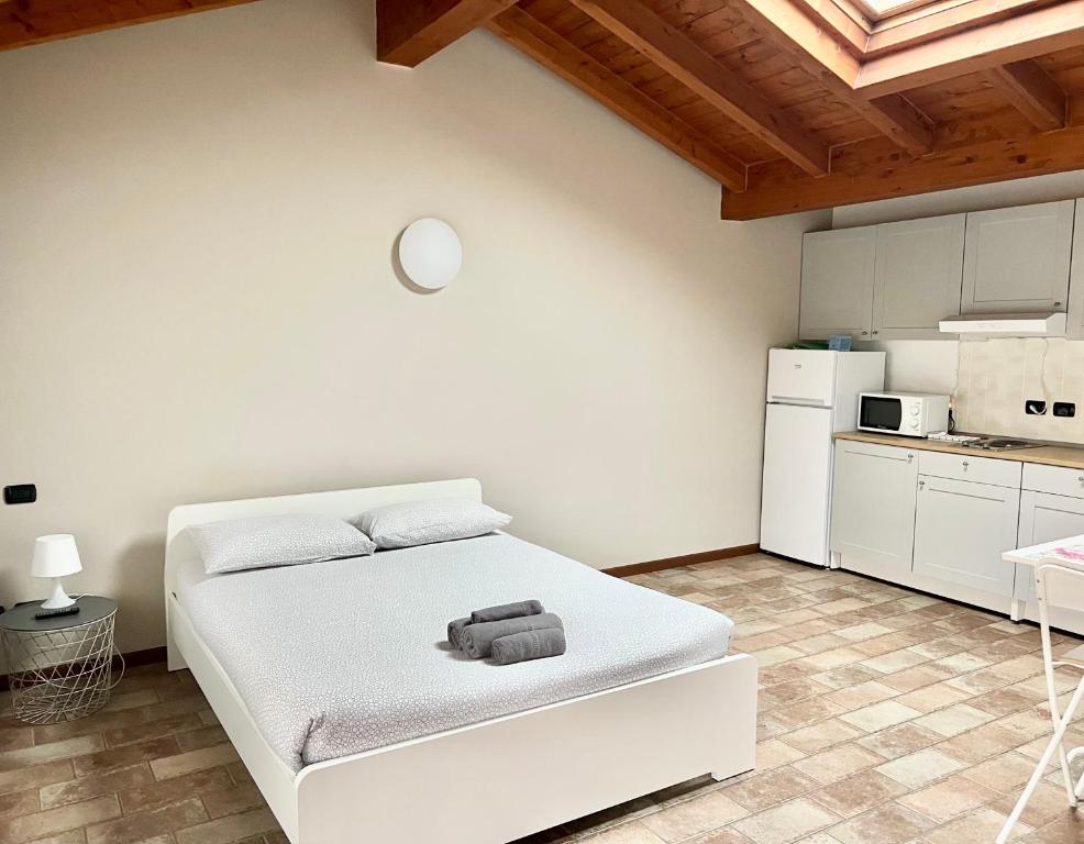 a white bedroom with a bed and a kitchen at Casa Cleopatra in Bergamo