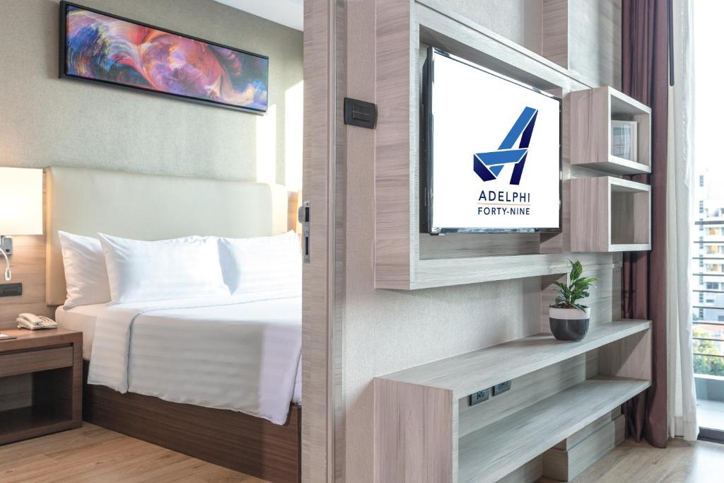 A bedroom and lounge view showing the bed, television, and balcony edge.