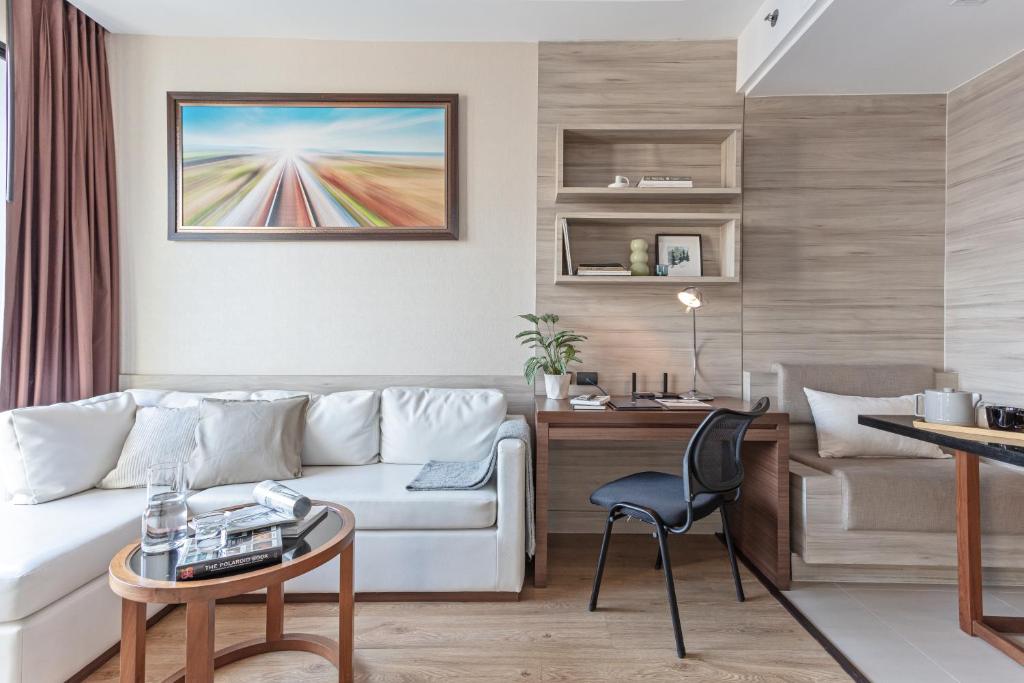 A living room combining a sofa, compact desk, and built-in shelving.