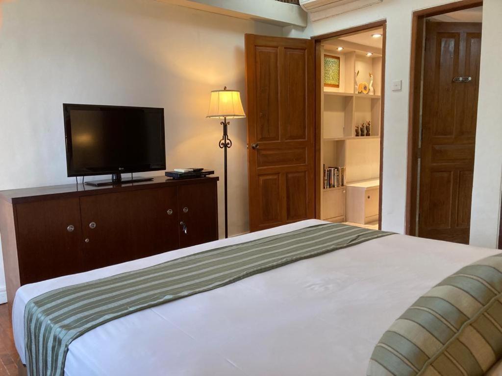 a bedroom with a bed and a flat screen tv at Coastal Suite at Jayakarta Residence in Seminyak