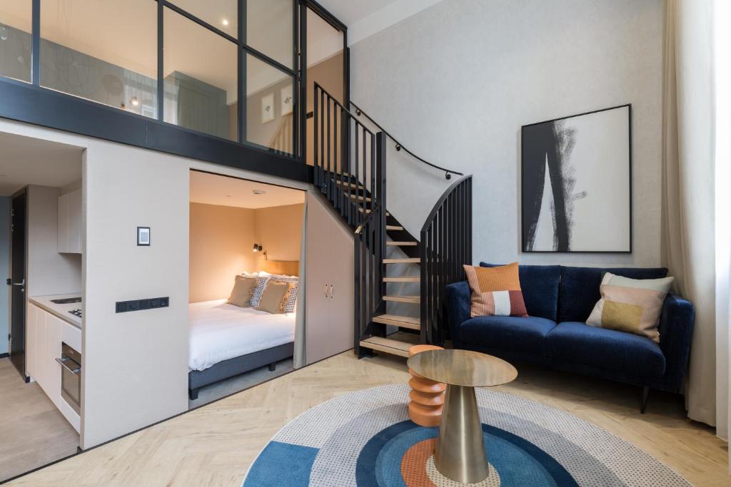 a small living room with a bed and a staircase at Ocean House Scheveningen in Scheveningen