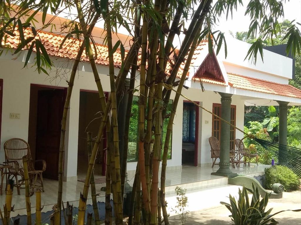 een huis met een groep bomen ervoor bij Green Garden Ayurvedic Resort & Green House in Varkala